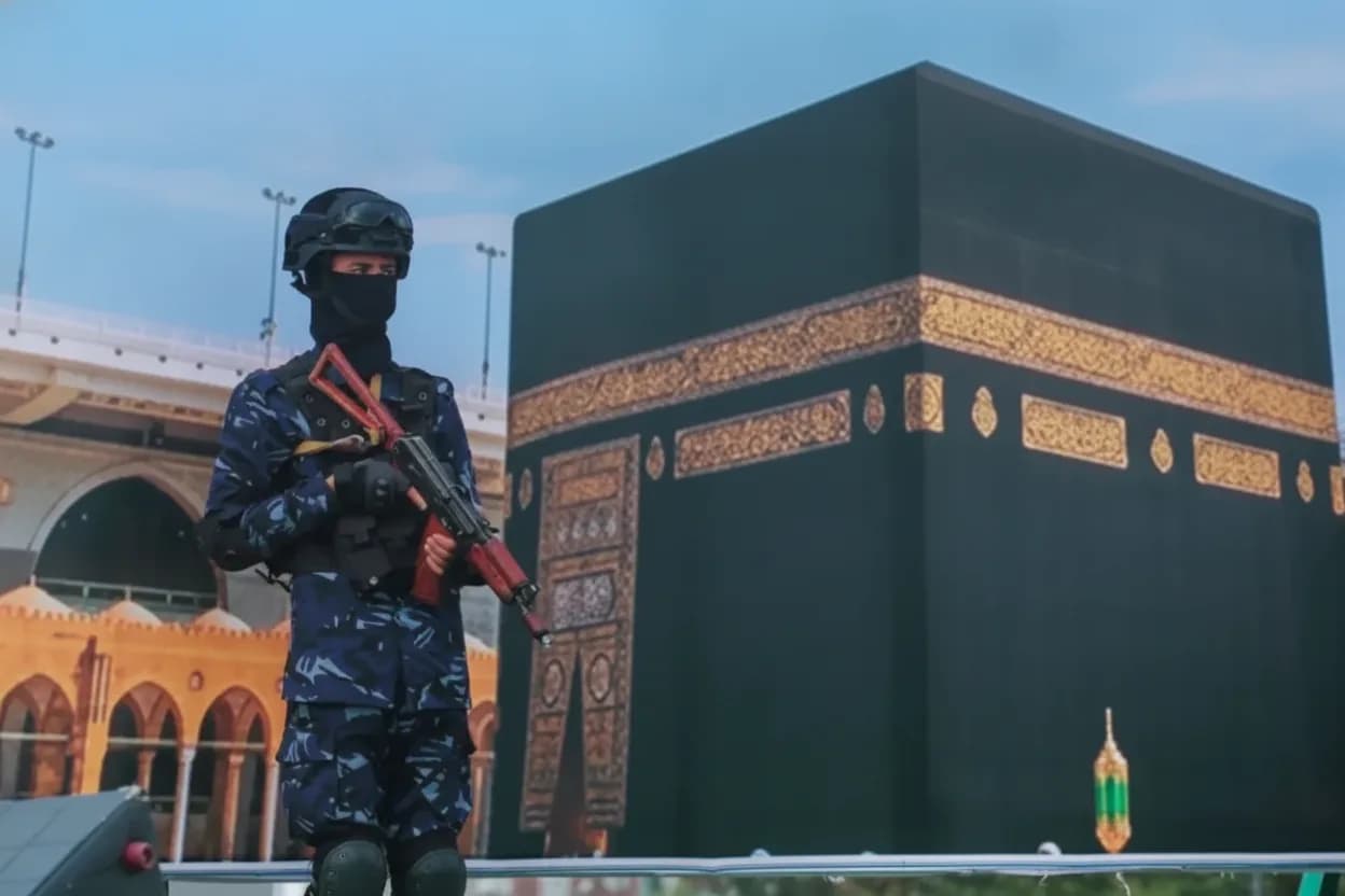 Un soldado hutí, delante de un cartel de grandes dimensiones con la imagen de la Kaaba.