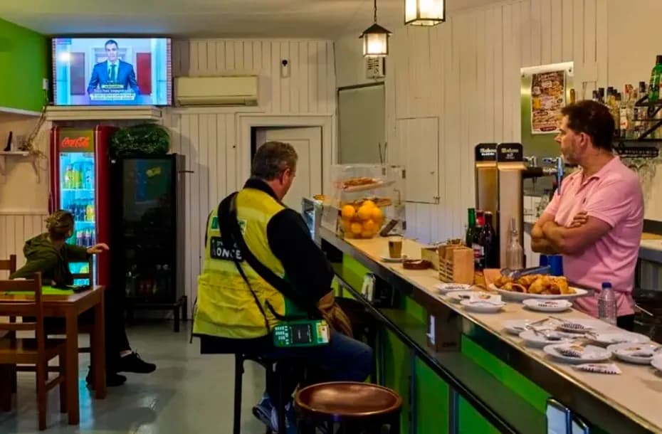 Unas personas en un bar de La Cabrera, a las afueras de Madrid (España), observan en televisión al presidente del Gobierno español, Pedro Sánchez, que anunció el adelanto de las elecciones generales.